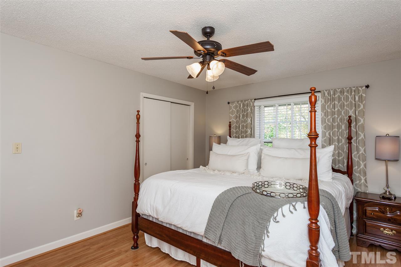 9409 Sauls Road Raleigh, NC 27603 - Photo 14 of 25 a bedroom with a bed and wooden floor