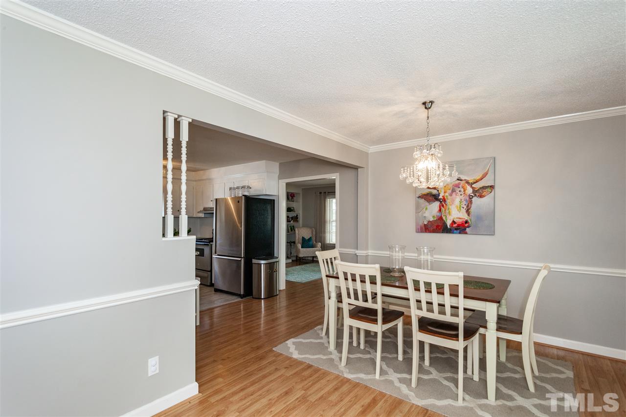 9409 Sauls Road Raleigh, NC 27603 - Photo 3 of 25 a view of a dining room with furniture wooden floor and chandelier