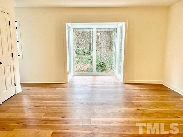 700 Lakestone Drive Raleigh, NC 27609 - Photo 14 of 35 a view of an empty room with wooden floor and a window