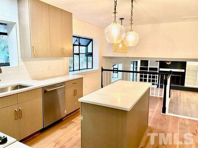 700 Lakestone Drive Raleigh, NC 27609 - Photo 4 of 35 a kitchen with kitchen island a stove a sink a dining table and chairs with wooden floor