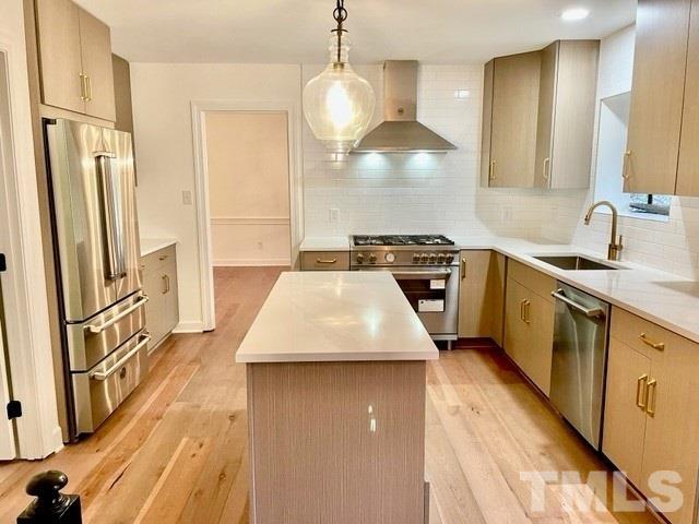 700 Lakestone Drive Raleigh, NC 27609 - Photo 5 of 35 a kitchen with a sink a refrigerator and trees