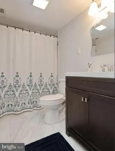 a bathroom with a sink a toilet and a mirror