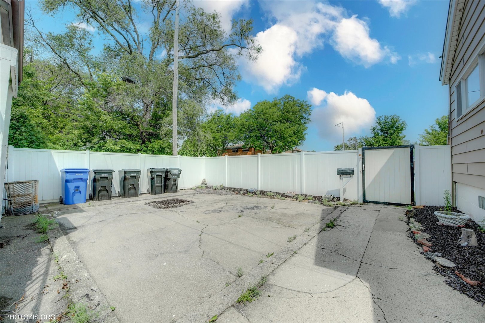 10004 South Torrence Avenue Chicago, IL 60617 - Photo 26 of 46 a backyard of a house with table and chairs plants and large tree