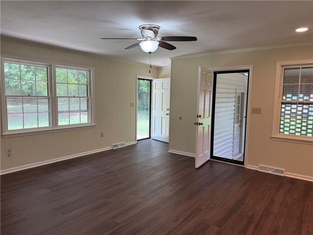 1507 East Calhoun Street Anderson, SC 29621 - Photo 8 of 18 Well-lit living area with dark wood flooring and multiple outdoor access points.