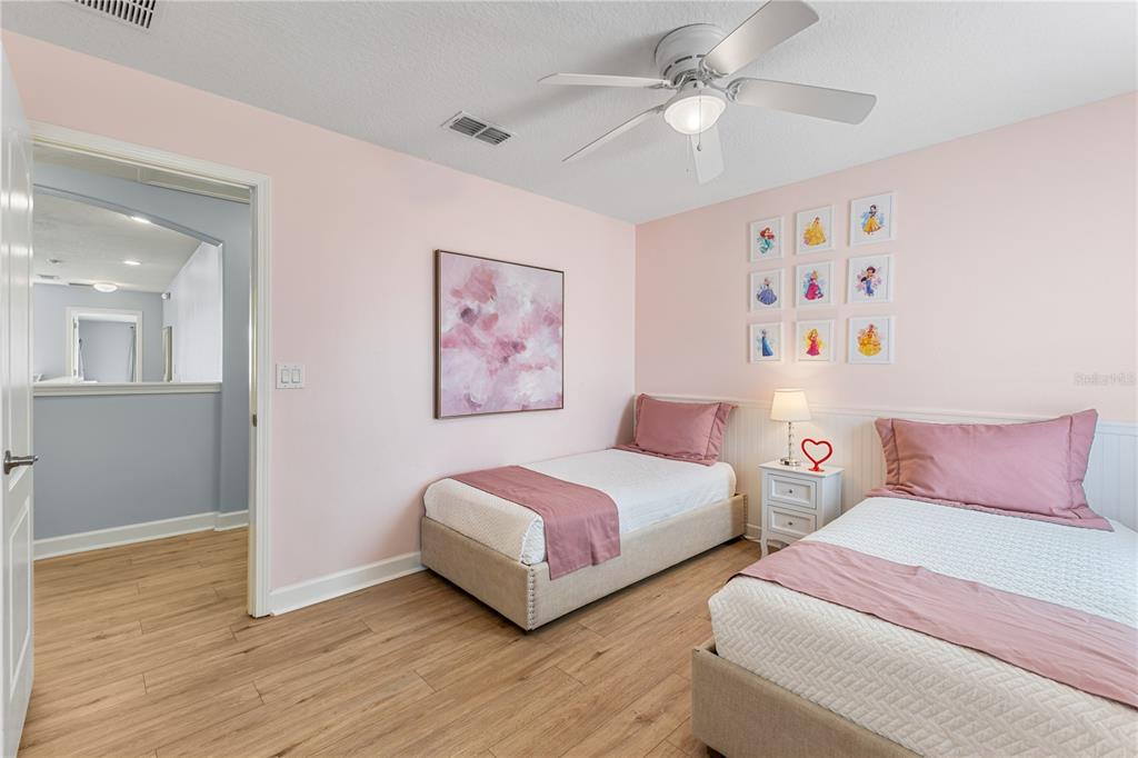 9006 Majesty Palm Road Kissimmee, FL 34747 - Photo 44 of 56 a bedroom with two beds and a chandelier