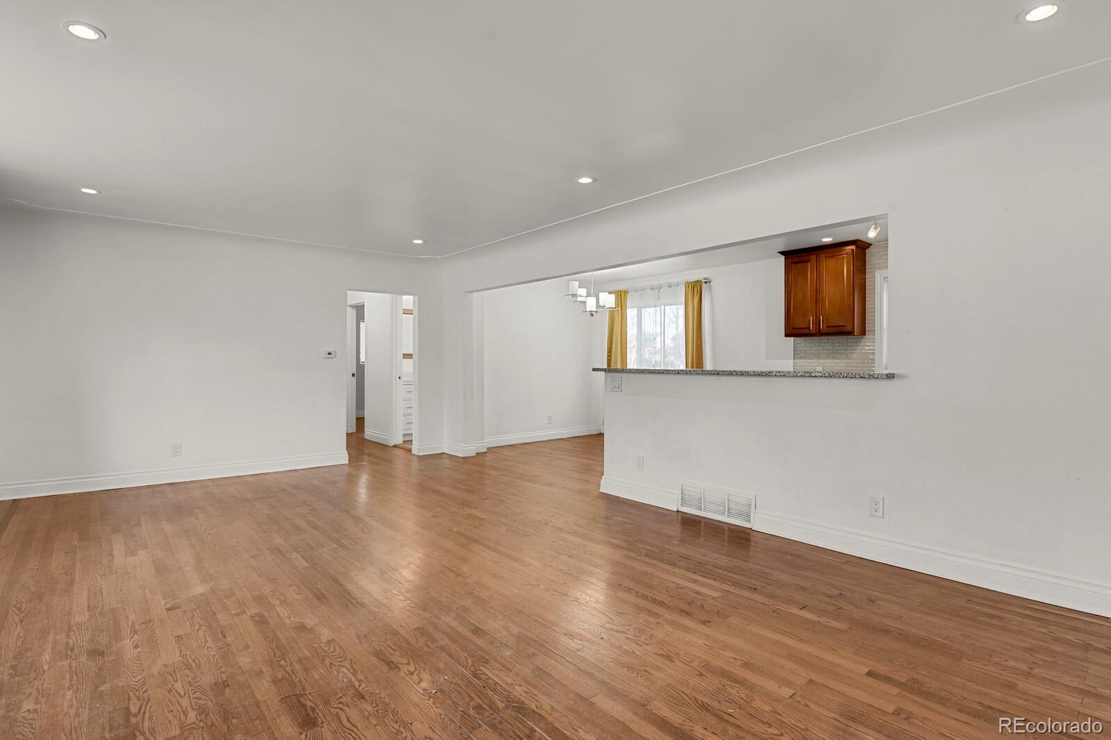 3720 Miller Street Wheat Ridge, CO 80033 - Photo 4 of 17 a view of an empty room with wooden floor and a window
