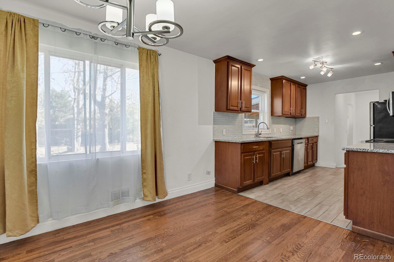 3720 Miller Street Wheat Ridge, CO 80033 - Photo 5 of 17 a kitchen with stainless steel appliances granite countertop a sink window and wooden floor