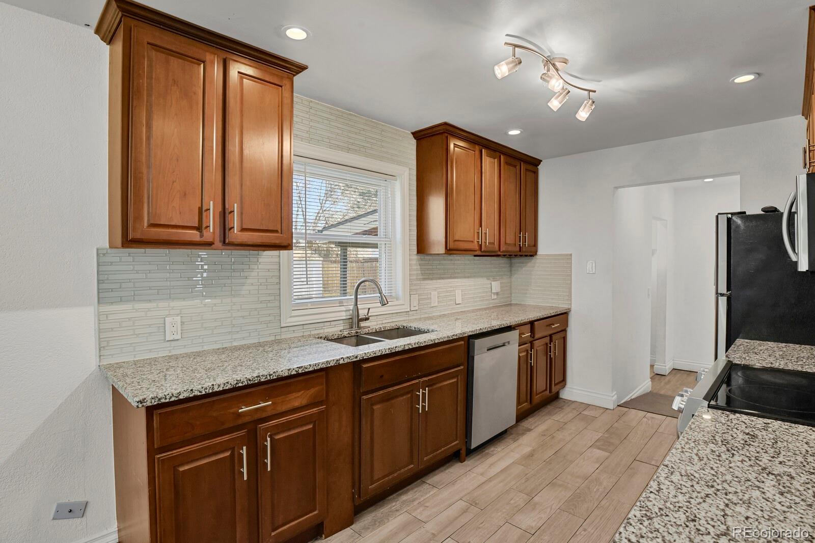 3720 Miller Street Wheat Ridge, CO 80033 - Photo 7 of 17 a kitchen with a sink appliances and cabinets
