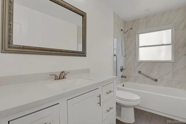 a bathroom with a toilet a sink a mirror and a bathtub