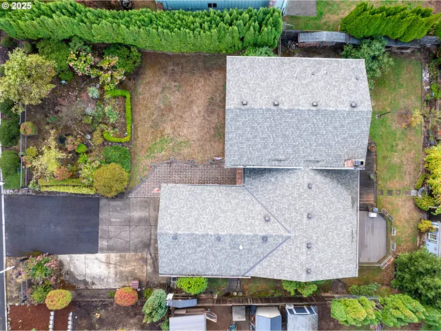 an aerial view of a house with a yard and a large tree