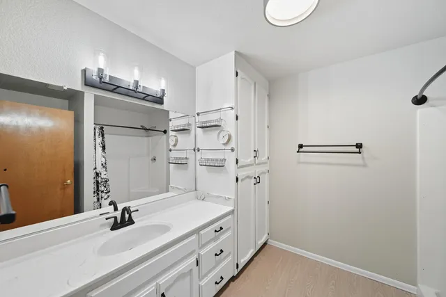 a bathroom with a double vanity sink a mirror and shower