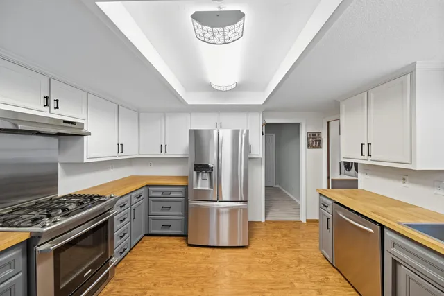 a kitchen with stainless steel appliances granite countertop a stove a refrigerator and a stove top oven