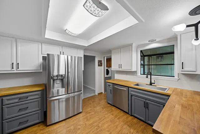 a kitchen with stainless steel appliances granite countertop a refrigerator and a sink