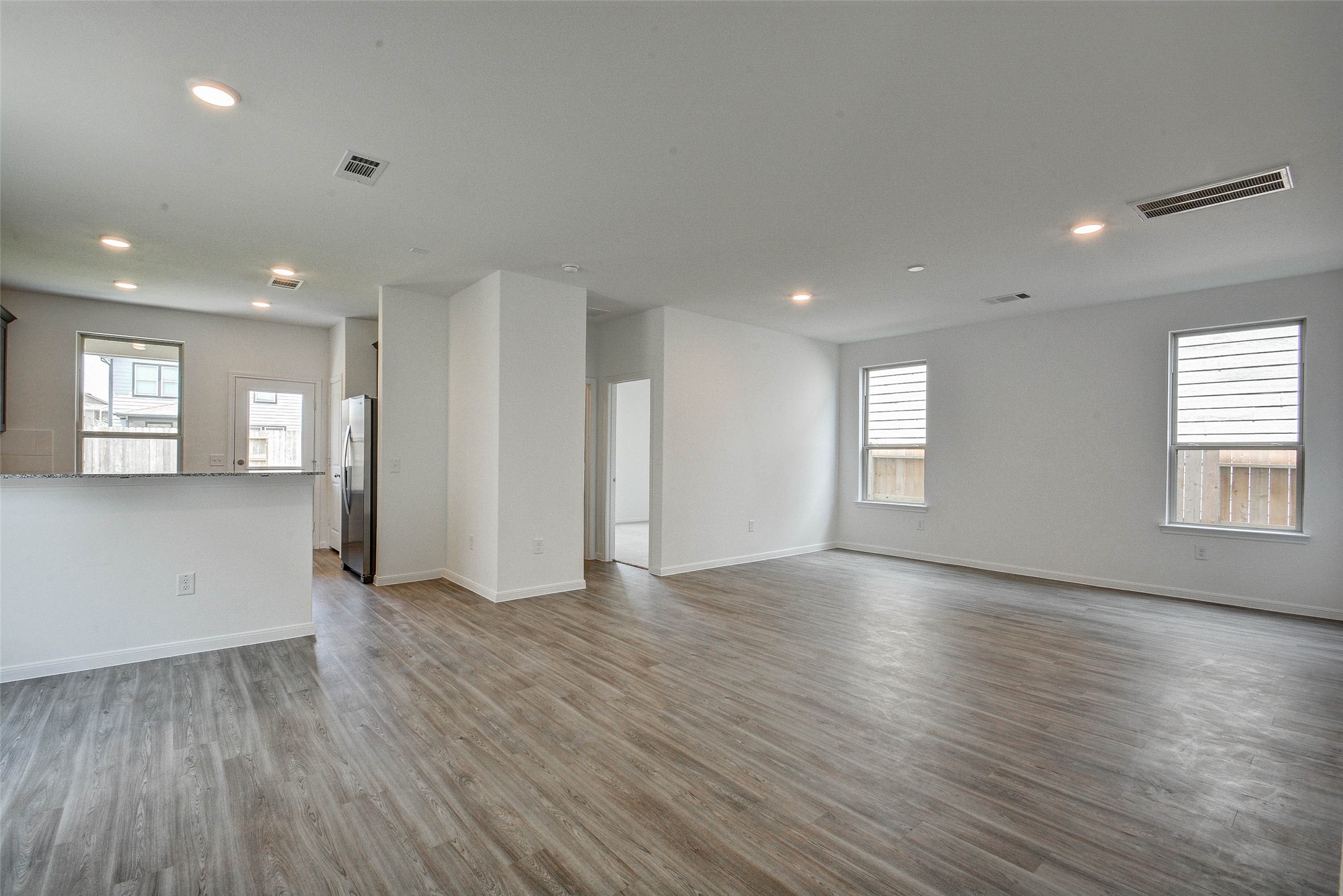 16642 Teak Mantle Road Conroe, TX 77302 - Photo 9 of 35 an empty room with wooden floor and windows