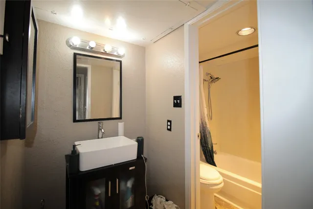 a bathroom with a sink mirror and a shower