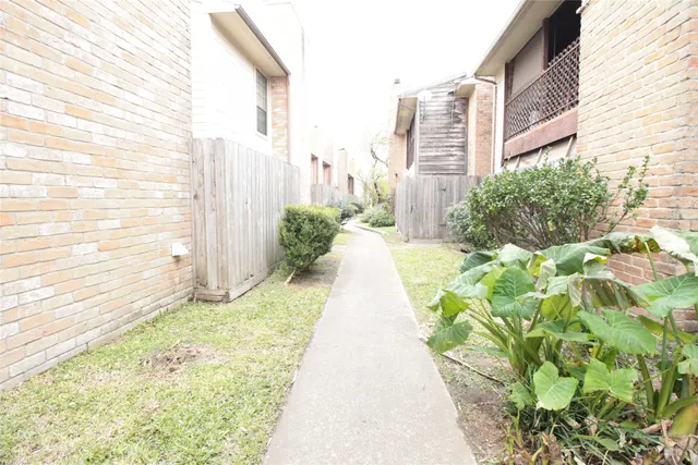 a view of a pathway with house in the background