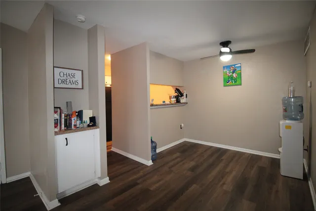 a view of a hallway with wooden floor and a bathroom