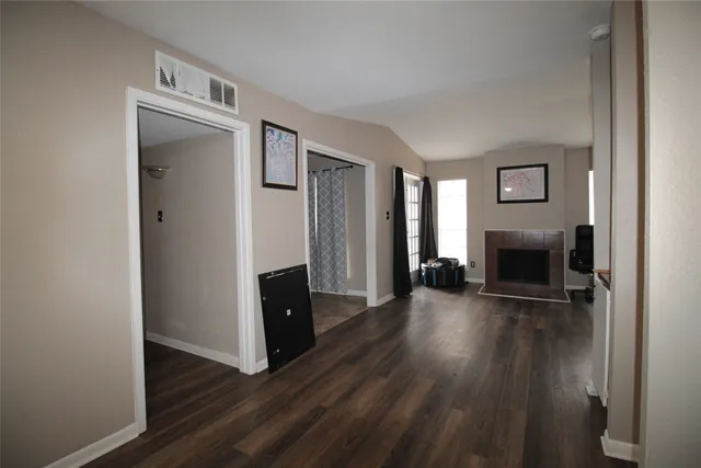 a view of a livingroom with wooden floor and a fireplace