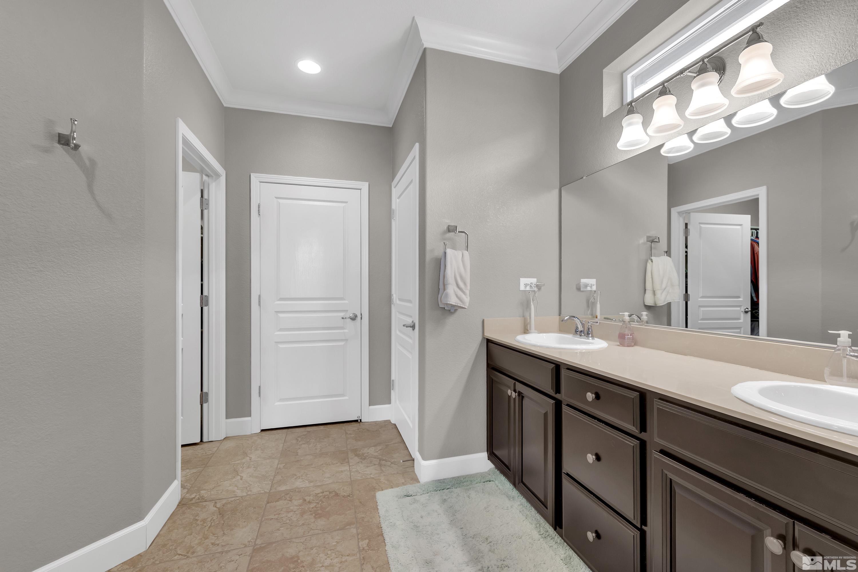 9255 Sassafras Trail Reno, NV 89523 - Photo 16 of 25 a spacious bathroom with a double vanity sink a large mirror and a shower