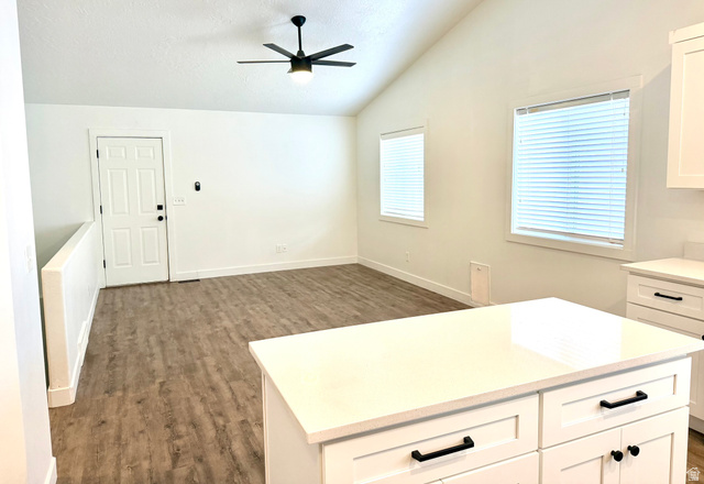 11895 Inauguration Road Draper, UT 84020 - Photo 4 of 13 Open-concept living space featuring wood-finish flooring, vaulted ceiling, and dual windows with blinds
