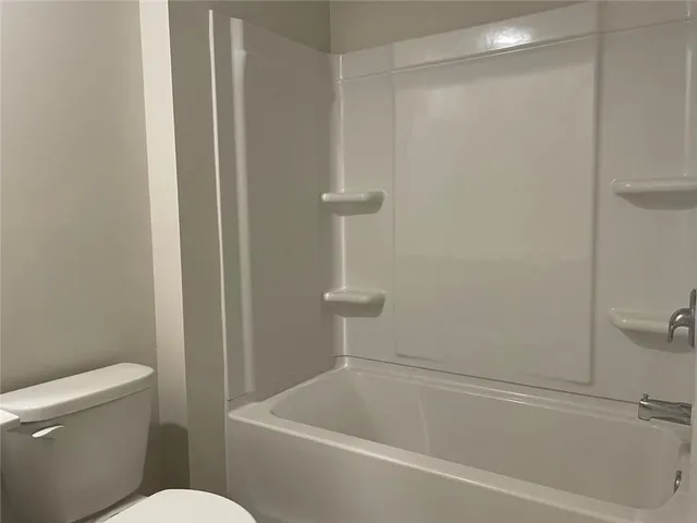a white bath tub sitting next to a toilet