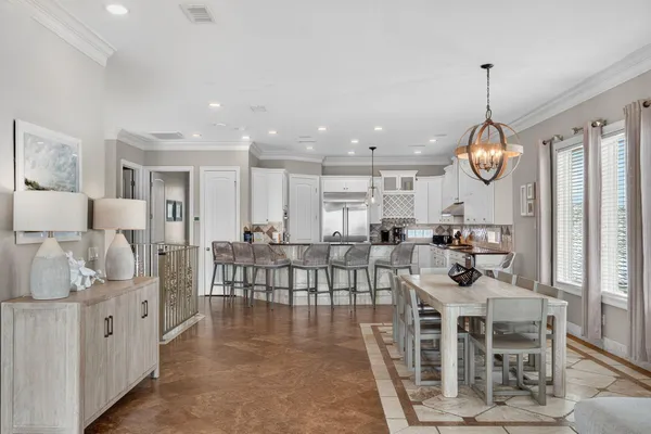 a living room with furniture a dining table chairs and a chandelier