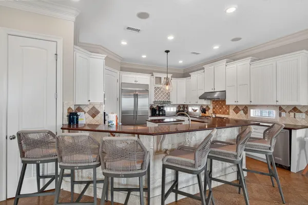 a kitchen with stainless steel appliances granite countertop a table and chairs