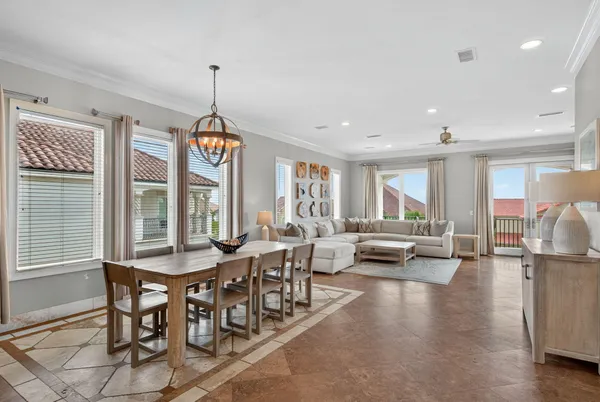 a view of a dining room and livingroom with furniture wooden floor a chandelier