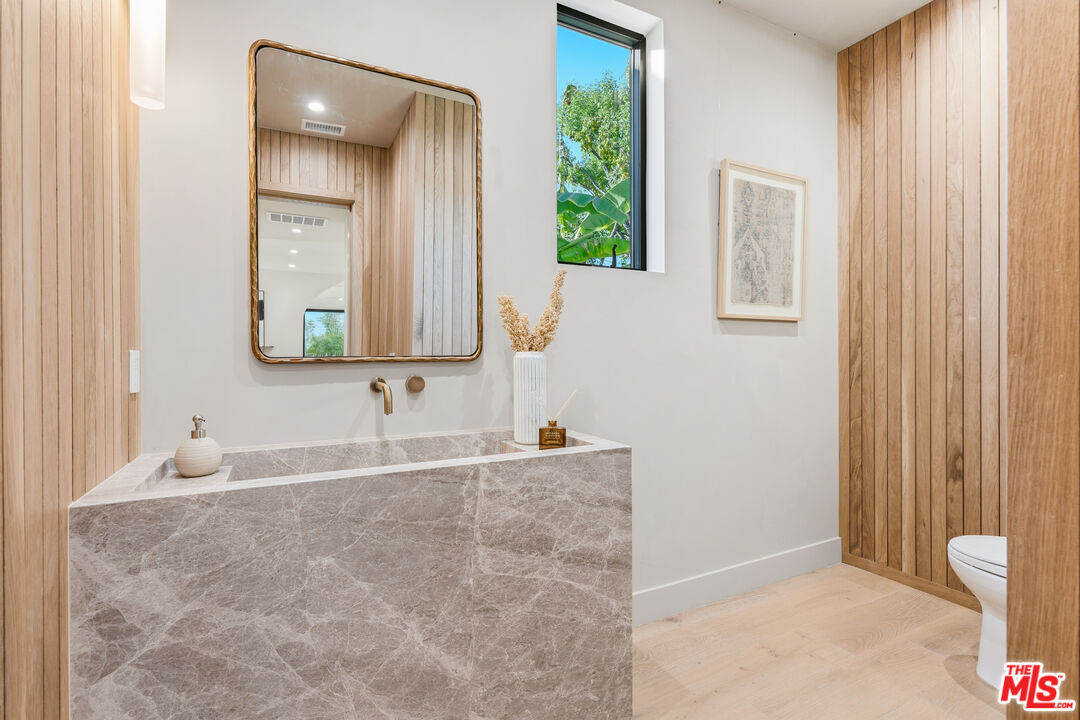 16643 Addison Street Encino, CA 91436 - Photo 13 of 31 a bathroom with a granite countertop sink and a mirror