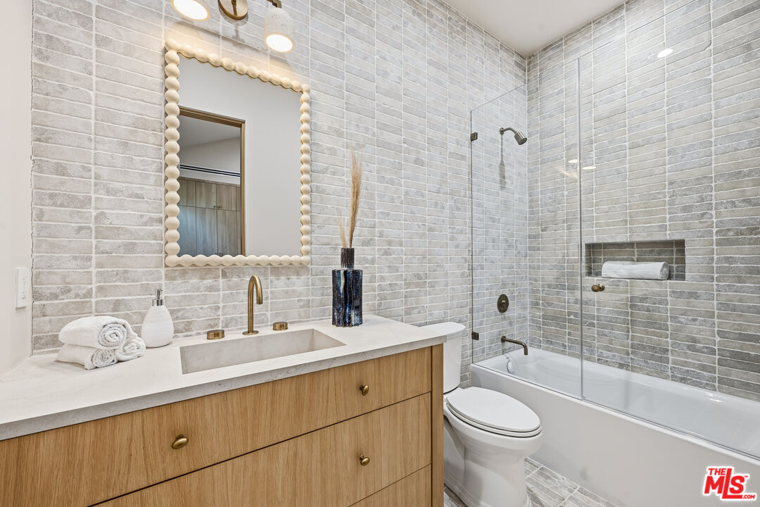16643 Addison Street Encino, CA 91436 - Photo 21 of 31 a bathroom with a granite countertop toilet sink and mirror