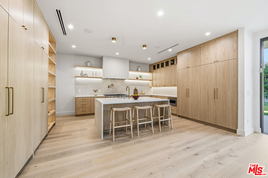 16643 Addison Street Encino, CA 91436 - Photo 7 of 31 a kitchen with kitchen island a appliances a table and chairs in it