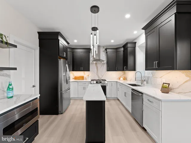 a kitchen with stainless steel appliances granite countertop a refrigerator a stove a sink a dining table and chairs