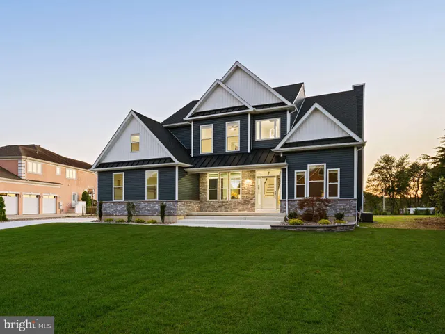 a front view of a house with a yard and trees
