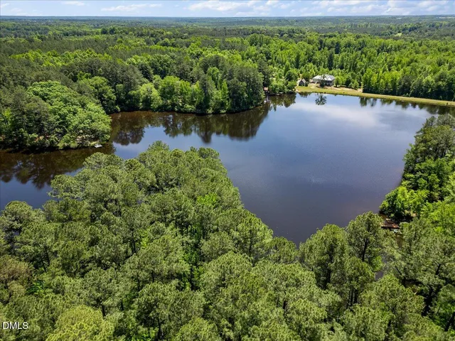 an aerial view of a house with a yard and lake view