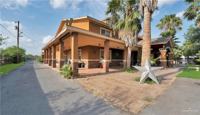 a view of a house with a yard and sitting area