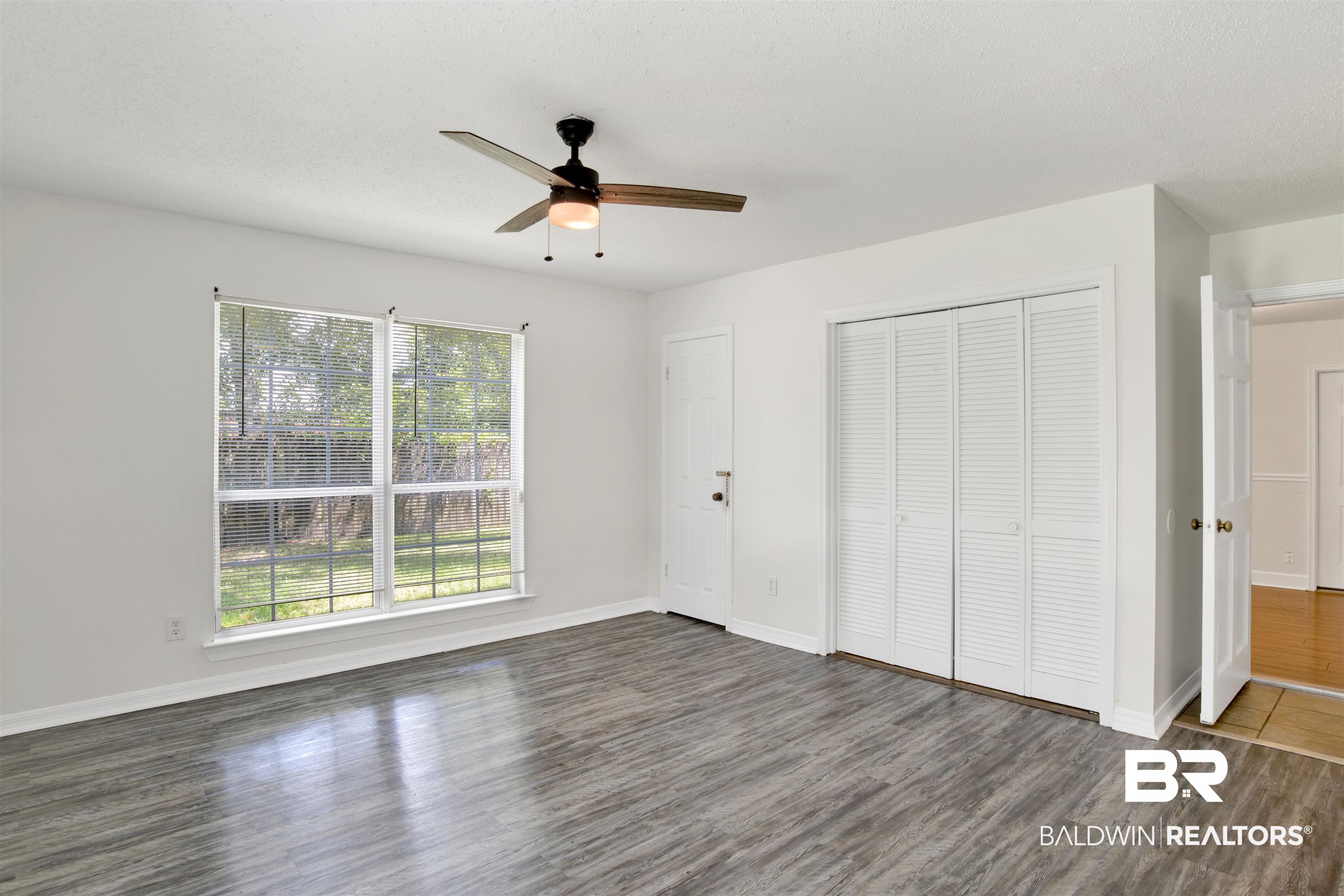 5480 Country Club Boulevard Theodore, AL 36582 - Photo 17 of 36 Unfurnished bedroom with a textured ceiling, dark hardwood / wood-style flooring, ceiling fan, and a closet