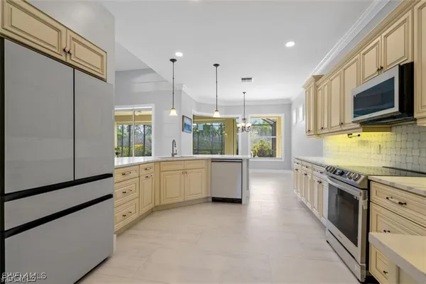 a large kitchen with stainless steel appliances granite countertop a stove a sink and a microwave
