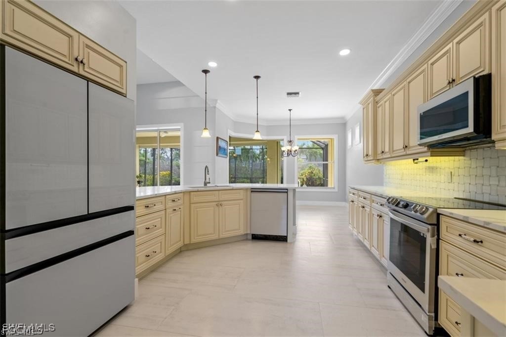 16113 Coco Hammock Way Fort Myers, FL 33908 - Photo 4 of 16 a large kitchen with stainless steel appliances granite countertop a stove a sink and a microwave