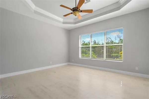 an empty room with a window and a fan