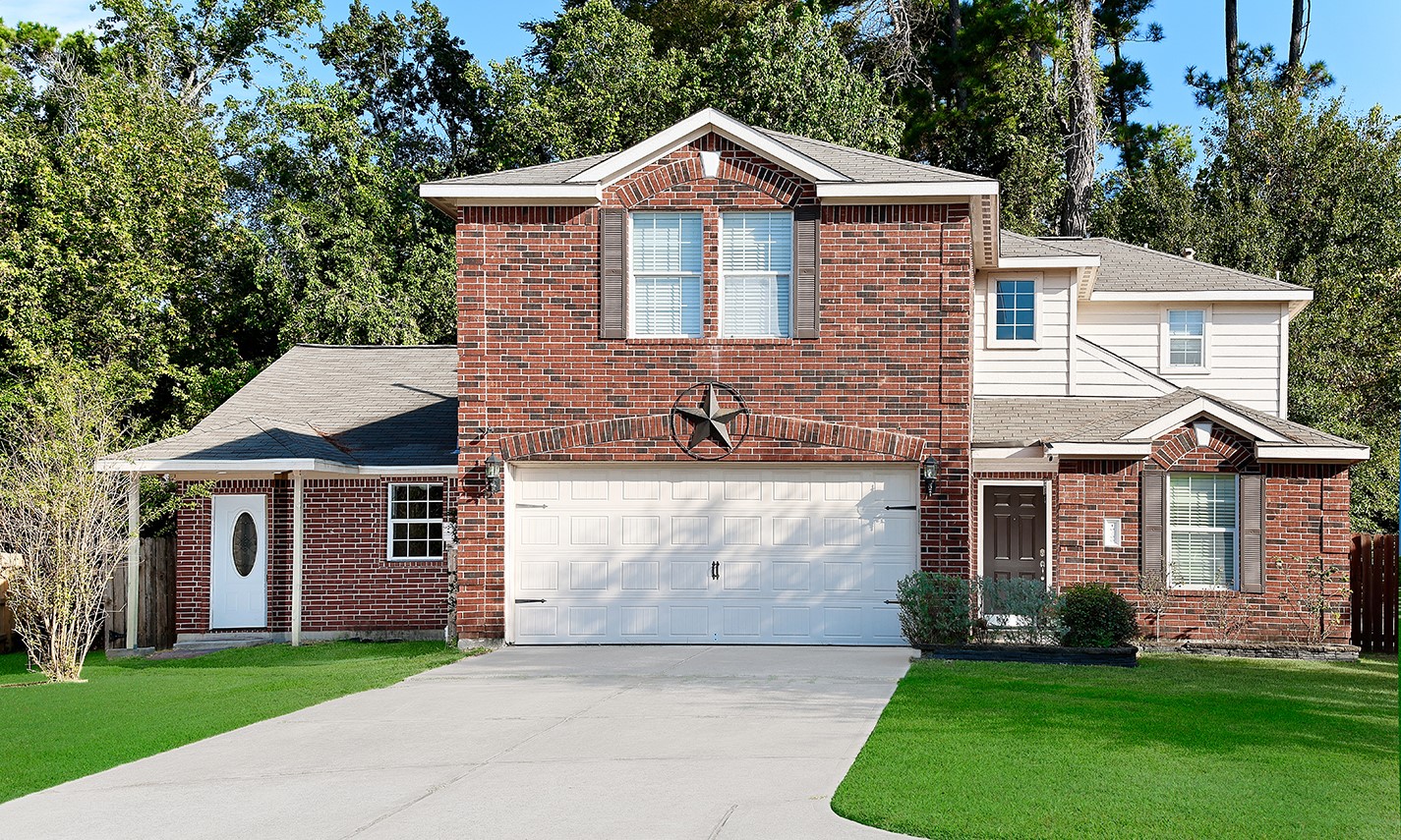 a front view of a house with a garden and yard