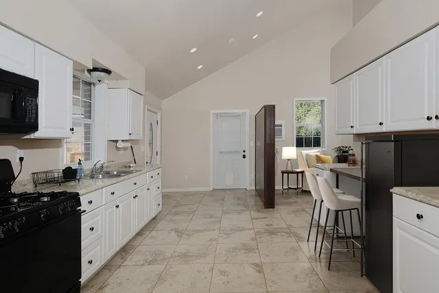 a kitchen with granite countertop a refrigerator stove top oven and sink