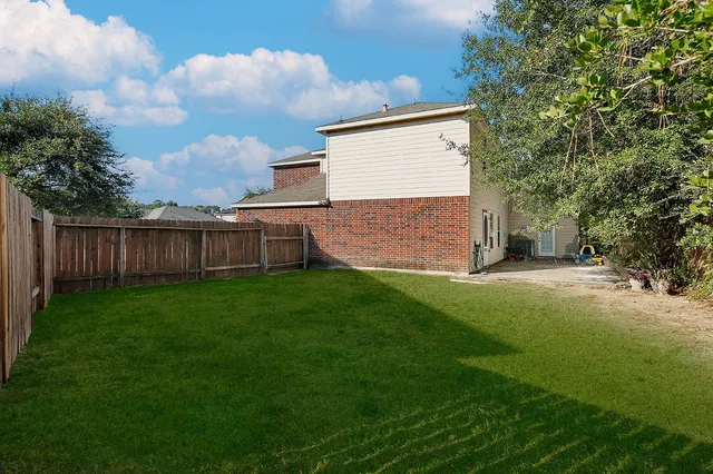 a view of a backyard with wooden fence