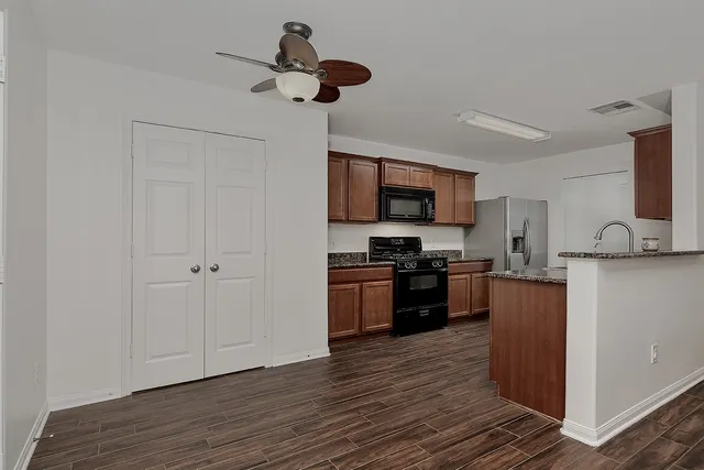 a kitchen with a refrigerator cabinets and wooden floor