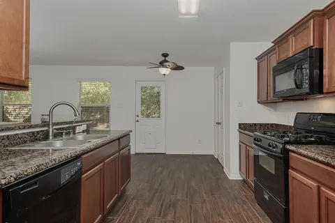 a kitchen with granite countertop stainless steel appliances a stove sink and microwave