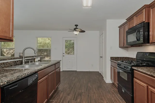 a kitchen with granite countertop stainless steel appliances a stove sink and microwave