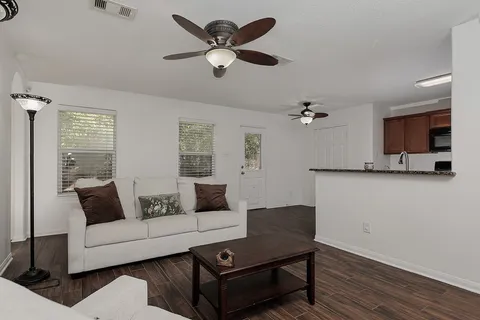 a living room with furniture and a wooden floor