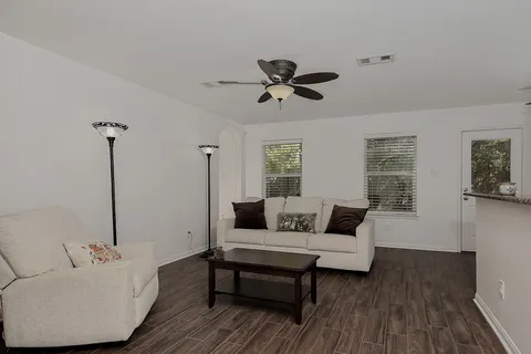 a living room with furniture and a wooden floor