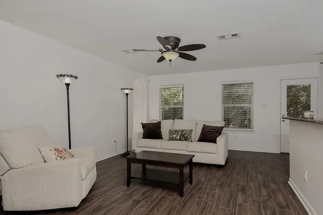 a living room with furniture and a wooden floor