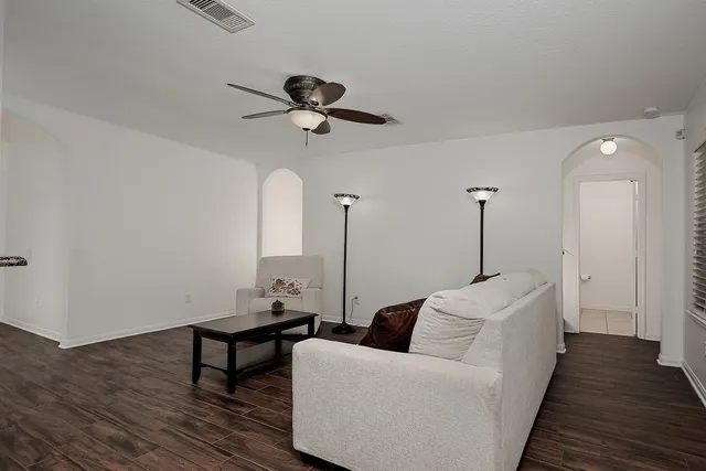 a living room with furniture and a wooden floor