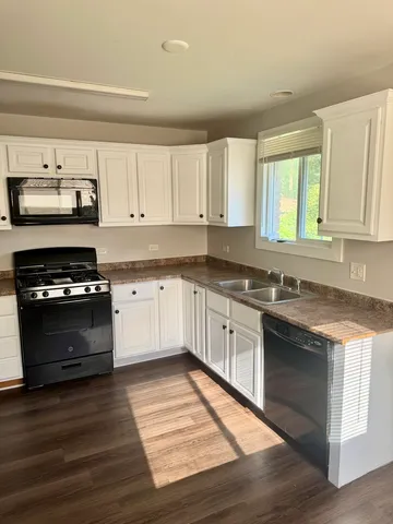 a kitchen with stainless steel appliances granite countertop a refrigerator a stove top oven a sink and dishwasher